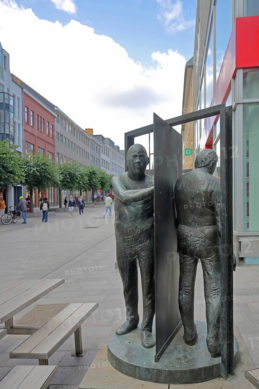 Sculpture revolving door by Waldemar Otto 1929, two, male figures, between, separated, opposite, separation, separated, in between, pedestrian zone, Königsstraße, Old Town, Lübeck, Schleswig-Holstein, Germany