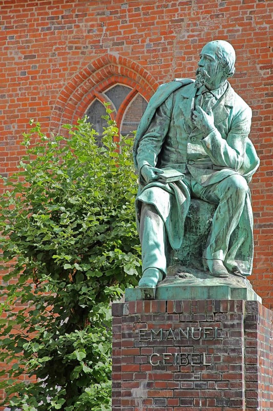 Monument to the writer and poet Emanuel Geibel by Hermann Volz 1889, seated, inscription, bronze sculpture, Grünspan, Geibelplatz, Old Town, Lübeck, Schleswig-Holstein, Germany