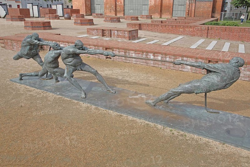 Tug-of-war by Karl-Henning Seemann 1987, bronze sculpture, modern art, tug-of-war, rope, sport, fighting, pulling, strength, St Mary's Church Tower, Wismar, Mecklenburg-Western Pomerania, Germany