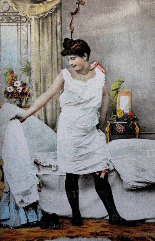 Female nude from around 1899, erotic postcard, playgirl, woman in nightgown looking at herself in the bedroom, which is decorated with flowers, coloured, reproduction of a photo from around the turn of the century, historical, digitally restored reproduction of an old original, exact date unknown