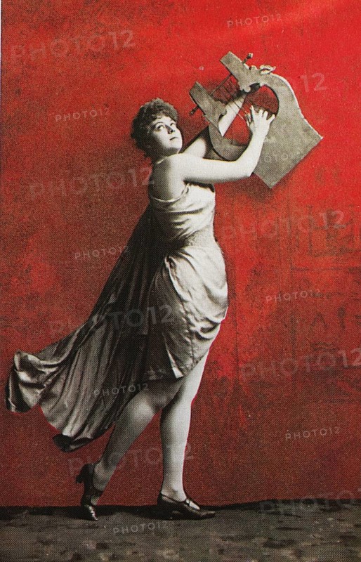 Female nude from around 1899, erotic postcard, playgirl, woman posing with an oversized harp in front of a bright red background, coloured, reproduction of a photo from around the turn of the century, historical, digitally restored reproduction of an old original, exact date unknown
