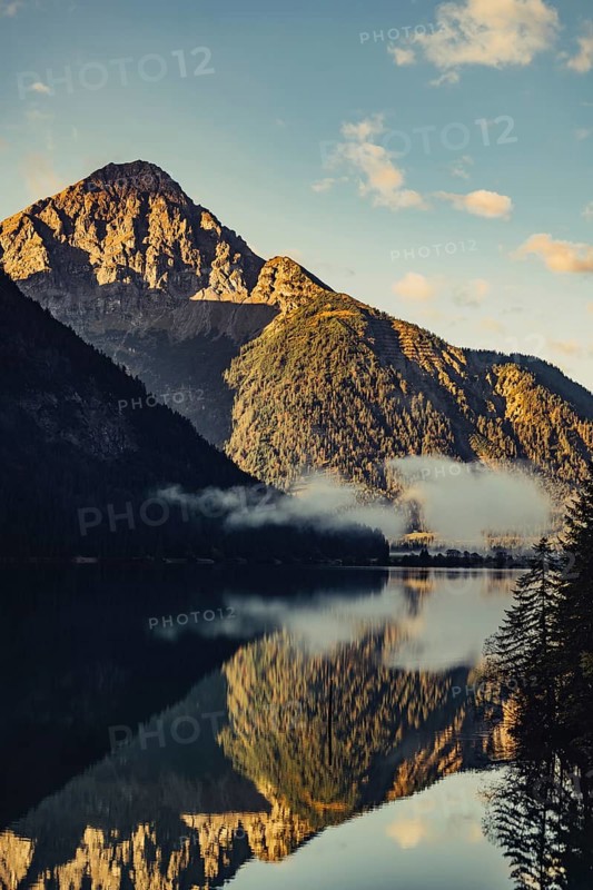 Sunrise with reflections and alpenglow in Lake Heiterwanger See in Tyrol in the Alps in Austria