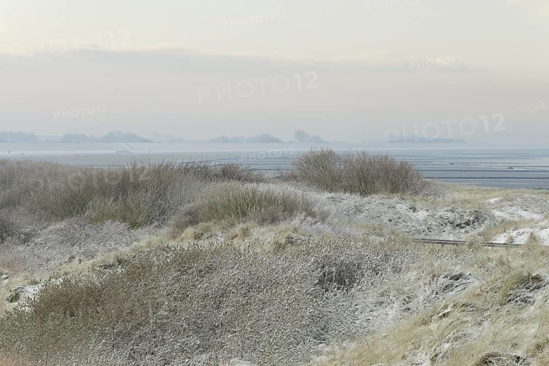 View over the snow-covered dune landscape of Norddeich, Wadden Sea at low tide, North Sea, Lower Saxony, Germany