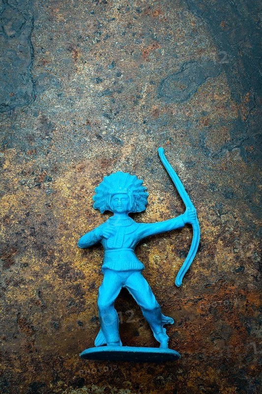 A vibrant blue plastic toy archer stands confidently, showcasing its detailed representation of an Indian Native American figure