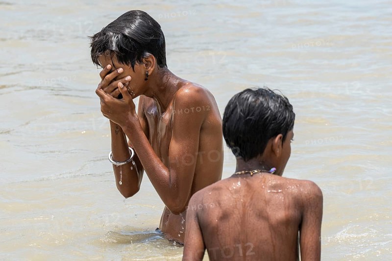 Children bathe in the Brahmaputra River to seek relief from the intense summer heat in Guwahati, India, on June 26, 2025