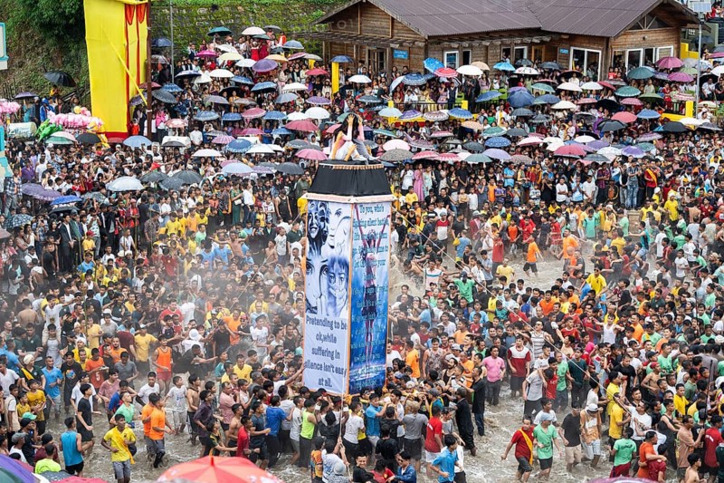 People from the Pnar community move around a Rot themed stop women harrasment as they celebrate an event organised to mark the Behdienkhlam festival in Jowai, India on July 14, 2025. Behdienkhlam is a vibrant annual festival celebrated by the Pnar (Jaintia) community of Meghalaya, especially in Jowai, to drive away plague and diseases and to pray for a good harvest. Observed in July after the sowing season, it features traditional rituals, offerings to ancestral spirits, and the grand procession of beautifully decorated bamboo structures called rots, which are later immersed in a sacred muddy pool known as Ka Aitnar