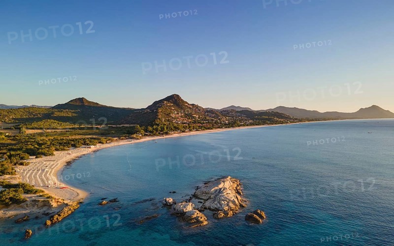 The light of the newly risen sun illuminates the Costa Rei, a stretch of coastline on the Italian Mediterranean island of Sardinia. (Aerial view with a drone), Monte Nai, Costa Rei, Sardinia, Italy