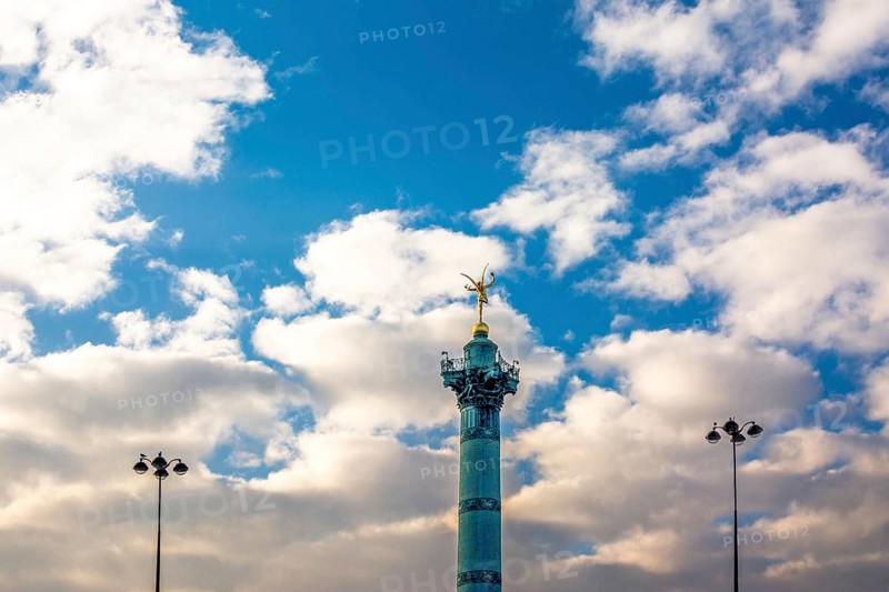 The July Column rises majestically in the Place de la Bastille, surrounded by fluffy clouds. This iconic landmark symbolizes freedom and history in Paris, showcasing its cultural significance. Paris. France