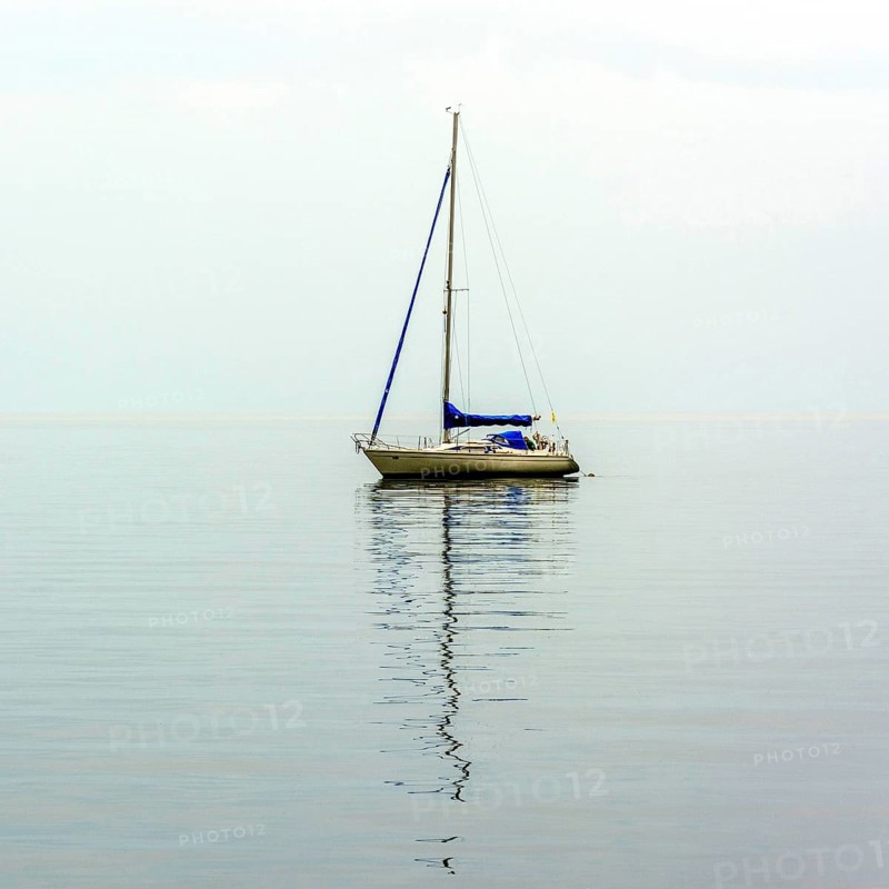 A sailing boat drifts smoothly over the serene waters of Lake Geneva, surrounded by a peaceful atmosphere. The soft ripples reflect the tranquility of the moment.. Switzerland
