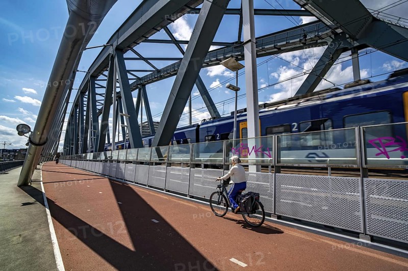 Cycle and pedestrian bridge Snelbinder Brug, over the river Waal near Nijmegen, was added to the existing railway bridge, fast cycle path connection from the city centre of Nijmegen and the new housing estates in the Waalsprong district, Netherlands