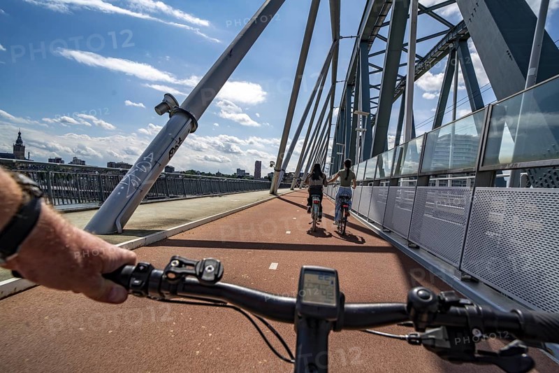 Ride over the Snelbinder Brug bicycle and pedestrian bridge, over the river Waal near Nijmegen, was built on the existing railway bridge, fast cycle path connection from the city centre of Nijmegen and the new housing estates in the Waalsprong district, Netherlands