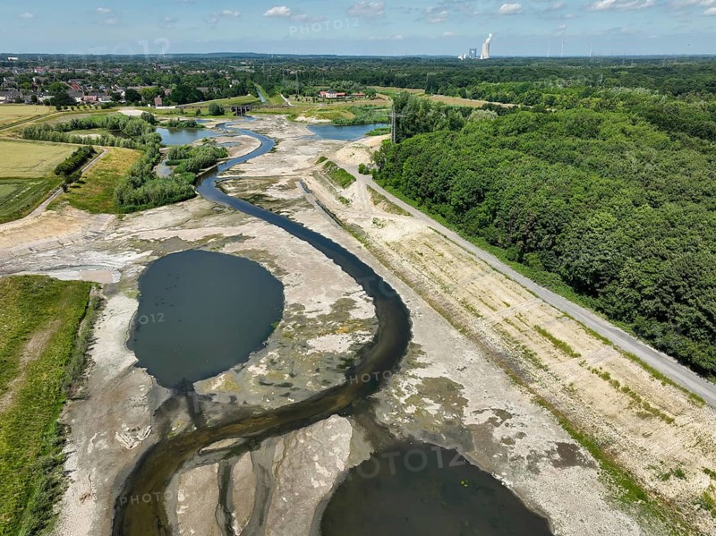Dortmund, Castrop-Rauxel, North Rhine-Westphalia, Germany - River renaturalisation, renaturation of the Emscher, flood retention basin HRB Mengede. A new floodplain landscape is being created at the Emscher-Auen farm, expanding the area for flood protection during heavy rainfall and for biodiversity. The previously straightened Emscher is being given curves again and can meander through its new floodplain. Following the construction of a parallel sewer, the Emscher has been completely free of sewage since 2022. The river was previously an open, above-ground mixed water channel with rainwater and wastewater. At the back right, the Uniper coal-fired power plant Datteln 4 power station