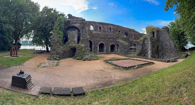 Panoramic photo of the ruins of the imperial palace of Emperor Frederick I Barbarossa, built in the Middle Ages around 1184 on the left in the background of today's banks of the Rhine, in the foreground small model of the original fortress building, Kaiserswerth, Düsseldorf, North Rhine-Westphalia, Germany