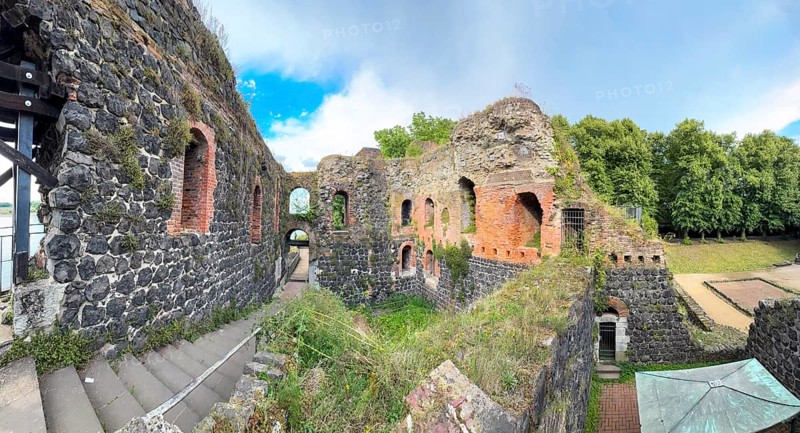 Panoramic photo of interior of northern inner part with partially restored secured masonry of ruins of imperial palace built in the Middle Ages around 1184 on today's banks of the Rhine by Emperor Frederick I Barbarossa, left staircase to upper floor, right at the edge of the picture today empty place of historic castle tower, tower of castle fortress, Kaiserswerth, Düsseldorf, North Rhine-Westphalia, Germany