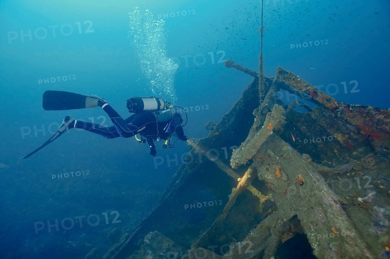 Diver floats near a shipwreck while air bubbles rise to the surface. Dive site wreck Michel C, Giens peninsula, Mediterranean Sea, Provence Alpes Côte d'Azur, France