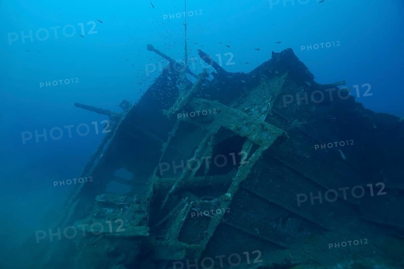 Rusty shipwreck lies quietly on the seabed under clear blue water. Dive site Wreck Michel C, Giens Peninsula, Mediterranean Sea, Provence Alpes Côte d'Azur, France