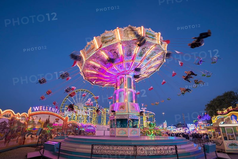 Brightly illuminated carousel at a night fair, chain carousel, spring festival, Cannstatter Wellenflug, illuminated, blue hour, Cannstatter Wasen, Bad Cannstatt, Stuttgart, Baden-Württemberg, Germany