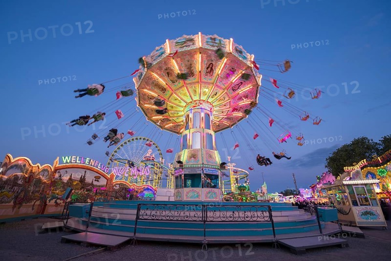 Colourful illuminated carousel turns on a funfair at night, chain carousel, spring festival, Cannstatter Wellenflug, illuminated, blue hour, Cannstatter Wasen, Bad Cannstatt, Stuttgart, Baden-Württemberg, Germany