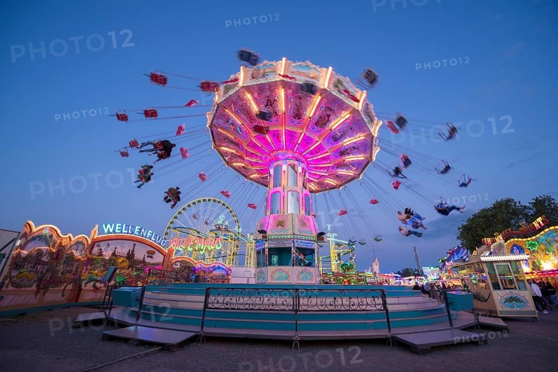 Colourful carousel in motion at a night fair, chain carousel, spring festival, Cannstatter Wellenflug, illuminated, blue hour, Cannstatter Wasen, Bad Cannstatt, Stuttgart, Baden-Württemberg, Germany