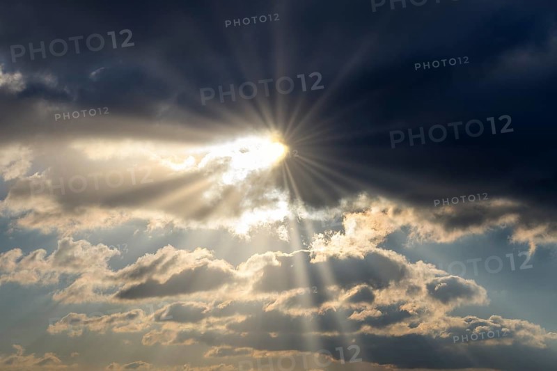 Dramatic rays of sunshine break through dark clouds in the sky, Baden-Württemberg, Germany