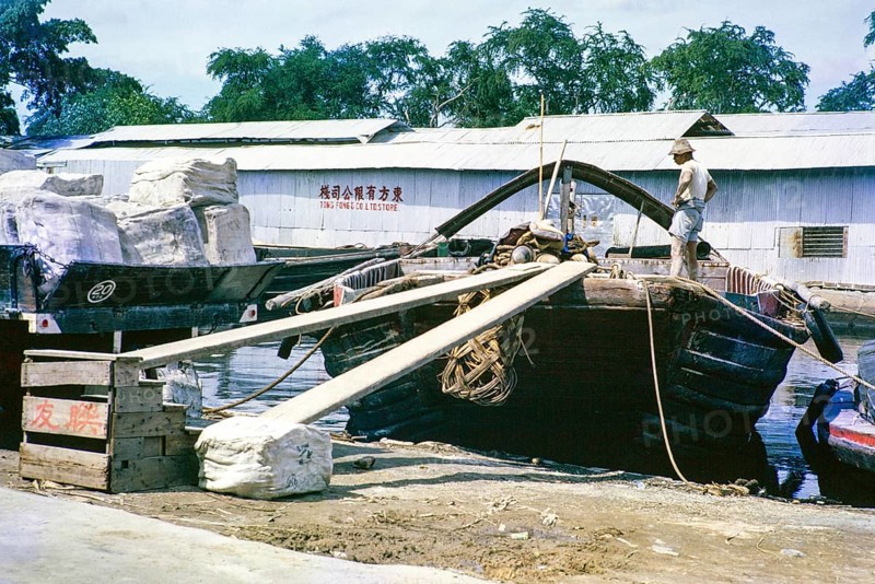 Loading rubber bales onto boat, Singapore River, Singapore, southeast Asia c 1963 Tong Fong Co Ltd Store warehouse in background