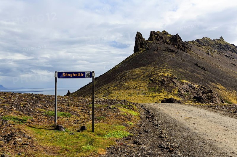 Gravel road with sign for place of interest, lava cave, Sönghellir lava tube, Stapafell mountain, Arnarstapi, Snaefellsjökull National Park, Snaefellsnes Peninsula, West Iceland, Iceland
