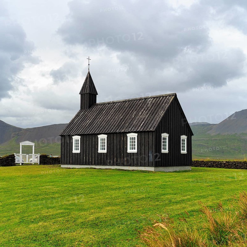 Traditional black church with white Tor tor in a meadow, wooden church Budakirkja, Búðir, Budir, Snaefellsnes Peninsula, Iceland
