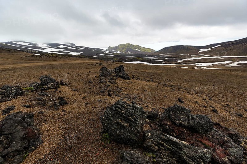 Barren volcanic landscape with snow fields, volcanic rock, mountain peaks with rain clouds, Snaefellsjökull, Snæfellsnes peninsula, Snaefellsnes, West Iceland, Iceland