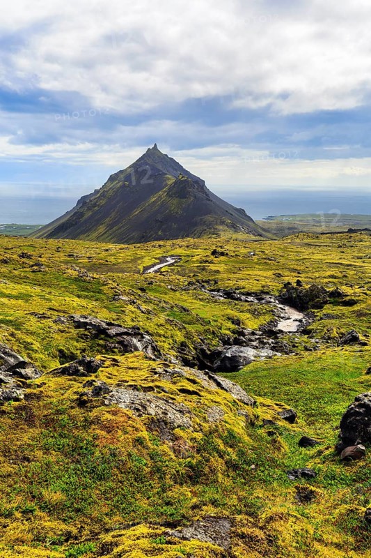Barren moss-covered volcanic landscape, cone-shaped mountain Stapafell, Arnarstapi, Snæfellsjökull volcanic system, Snaefellsnes peninsula, West Iceland, Iceland