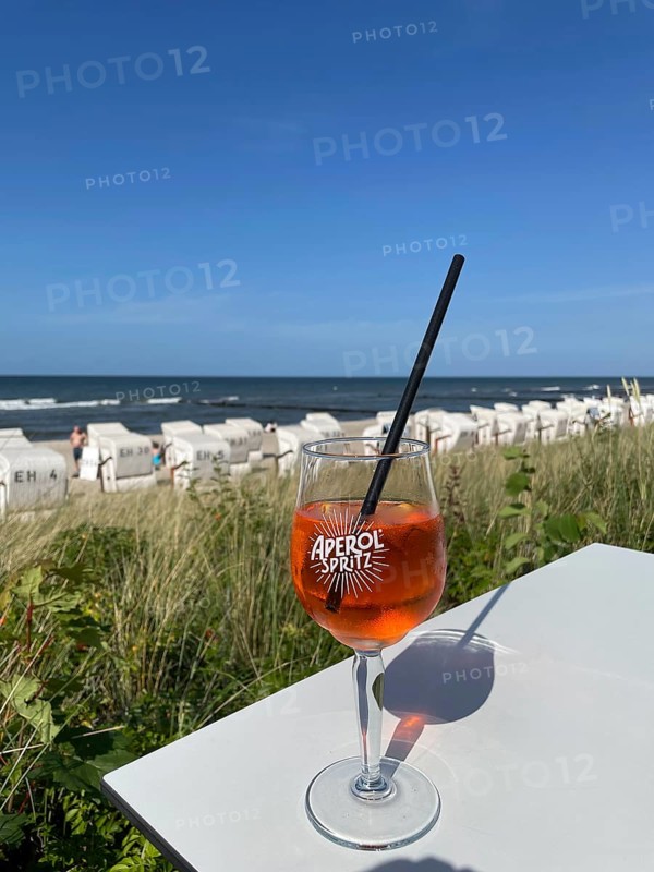 Glass of Aperol Spritz on a table overlooking the beach, Baltic resort Kühlungsborn, Mecklenburg-Vorpommern, Germany