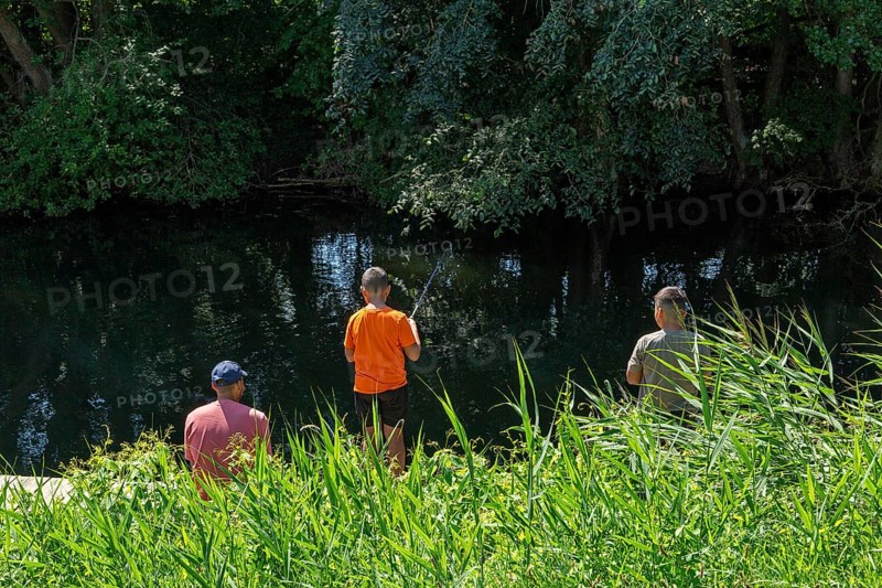 Father and sons fishing, Alte Fahrt canal, Bolter lock, Mecklenburg Lake District, Mecklenburg-Western Pomerania, Germany