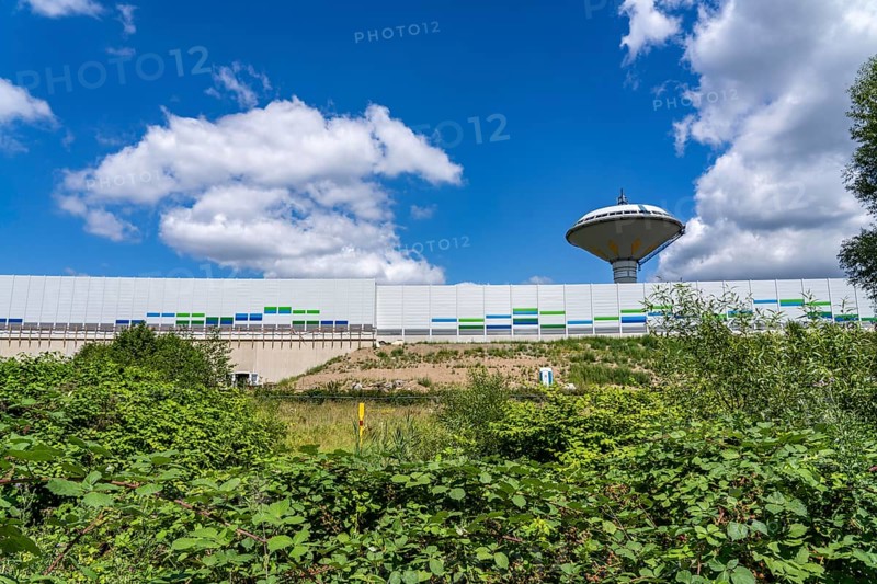 Green corridor with the river Dhünn, 40 km long river that flows into the Wupper near Leverkusen, renaturalised section, here shortly in front of the mouth along the A1 motorway, at the Leverkusen-West junction, noise barrier, landmark Leverkusen water tower, North Rhine-Westphalia, Germany