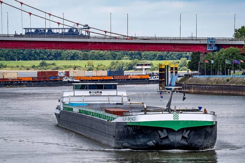 Barge enters the Vinckekanal, in the harbour of Ruhrort, container freighter on the Rhine, on an uphill journey, Friedrich-Ebert-Bridge, road bridge over the Rhine between Homberg and Ruhrort, Thyssenkrupp Steel steelworks, Duisburg, North Rhine-Westphalia, Germany
