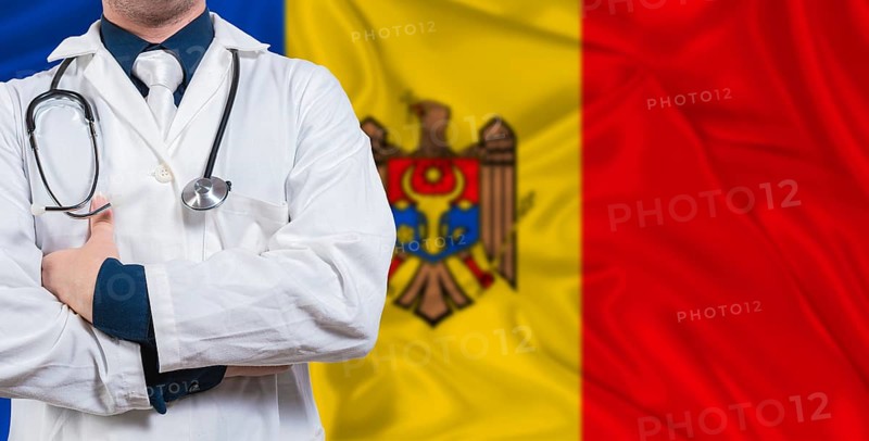 Male doctor with stethoscope on Moldova flag. Doctor holding stethoscope on Moldova flag