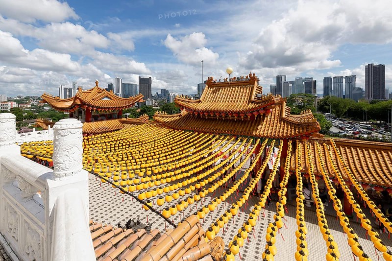 Thean Hou Temple to the Goddess Mazu with yellow chines lanterns and Kuala Lumpur skyline, Malaysia, Asia