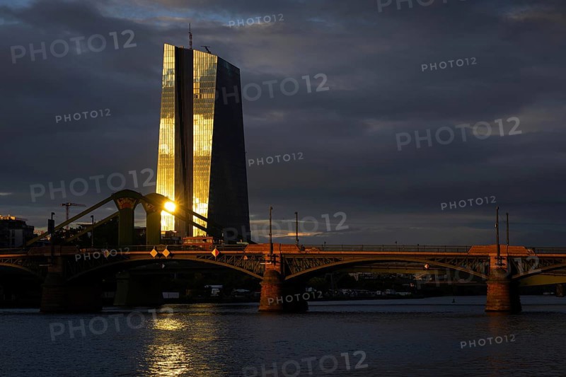 The light of the setting sun is reflected on the glass façade of the European Central Bank (ECB) in Frankfurt am Main, Frankfurt am Main, Hesse, Germany