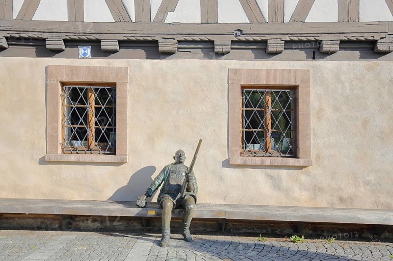 Sculpture Herbert König Suhl original in front of the arms museum, bronze sculpture, hunter with shotgun, rifle, sitting, Suhl, Franconia, Thuringia, Germany