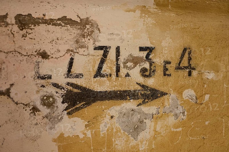 Lost Place, Ruin of a barracks, Patched wall with arrows and numbers in black on yellow, weathered plaster, Italian anti-aircraft position, Ground defence position, PL306 with 6 cannons, WW2, Vigla Mountain, Vigla, above Lakki, Lakki, Leros, Dodecanese, Girech Islands, Greece
