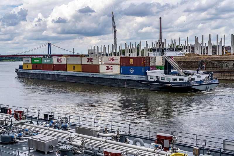 Construction of a new logistics hall on the Mercatroinsel, Hall 2, next to an existing hall, approx. 25, 000 square metres in size, in Duisburg-Ruhrort, shell construction, container freighter leaving the port canal for the Rhine, North Rhine-Westphalia, Germany