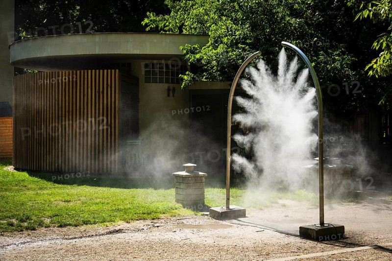 A mobile spray arch sprays fine water mist in a park in Bratislava, Slovakia