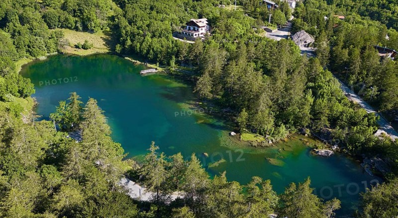 Aerial view Bird's eye view of small mountain lake Alpine lake Lago Grande near Moncenisio behind it Chalet on the lake, Val Cenischia, Graian Alps, Moncenisio, Piedmont, Italy