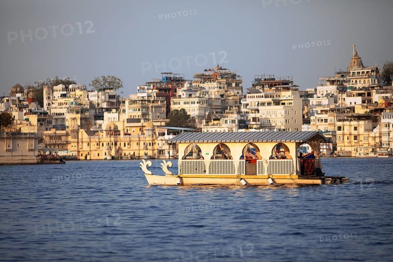 Excursion boats on Lake Pichola, behind the old town in the evening light, Udaipur, Rajasthan, India
