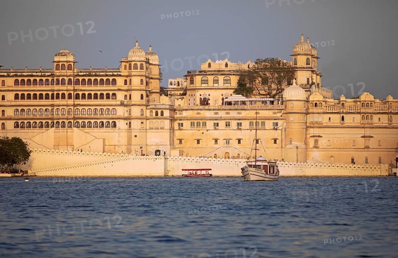 Excursion boats on Lake Pichola, behind the City Palace in the evening light, Udaipur, Rajasthan, India