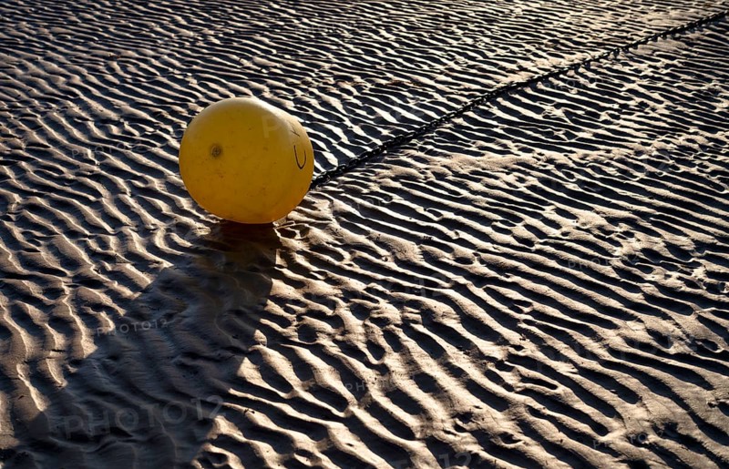 Buoy, yellow, on the sandy beach, Grandcamp-Maisy beach, low tide, evening light, Normandy, Calvados, France