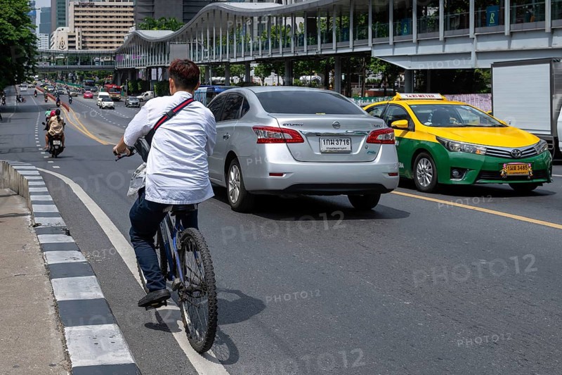 Road traffic cyclists and cars, Bangkok, Thailand