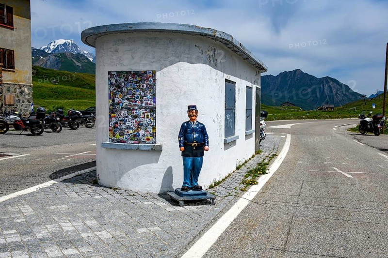 Disused former border house for passport control at the border crossing between France and Italy, in front of it a figure of a French border official, Graian Alps, Département Savoie, France, Valle d'Aosta, Italy