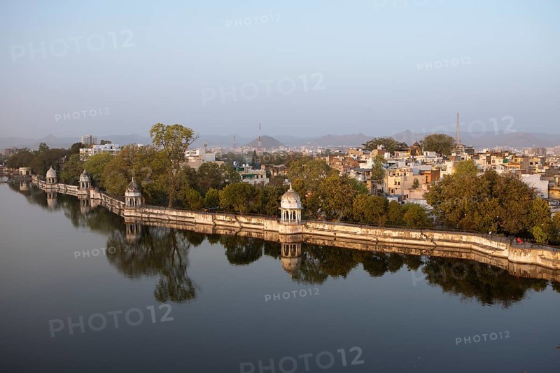 Pagodas in Swaroop Sagar Garden at Swaroop Sagar Lake in evening light, the city in the background, Udaipur, Rajasthan, India