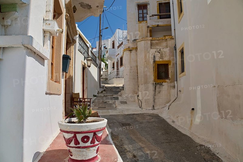 Narrow alley with white buildings and flower pot, old plaster, quiet and sunny atmosphere, Agia Marina, Leros, Dodecanese, Greek Islands, Greece
