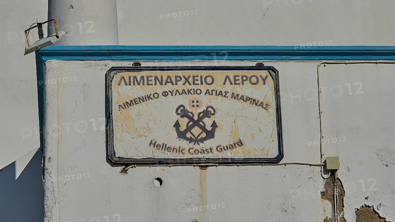 Worn sign of the Hellenic Coast Guard on a white wall, Agia Marina, Leros, Dodecanese, Greek Islands, Greece