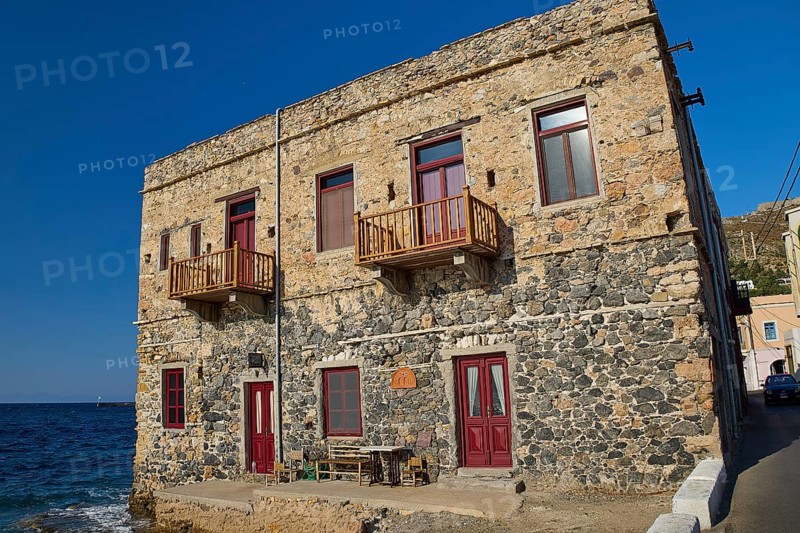 Two-storey stone house with red windows right by the sea, rustic charm, Agia Marina, Leros, Dodecanese, Greek Islands, Greece